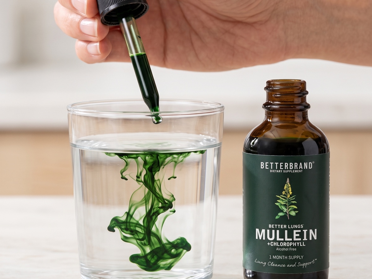 Two droppers of BetterLungs being added to a glass of water